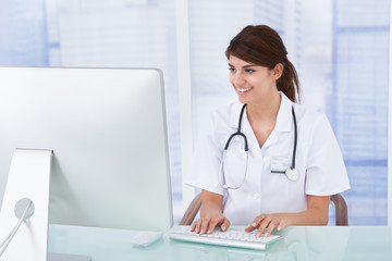 Doctor Using Computer At Desk In Clinic