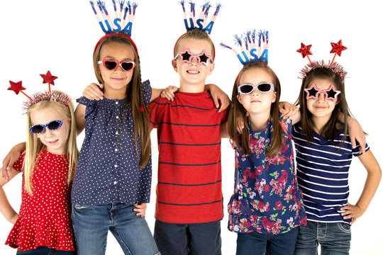 Five patriotic children standing arm in arm smiling