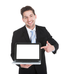 Confident Businessman Displaying Laptop Over White Background