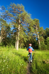 Obraz premium Boy on bike in the forest