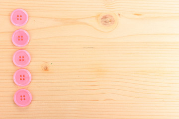 Colorful sewing buttons on wooden background