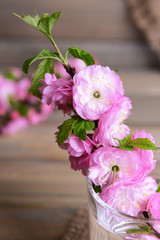 Beautiful fruit blossom in glass on table on grey background