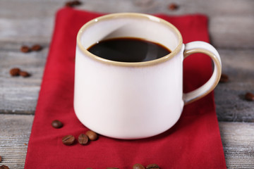 Cup with hot coffee and roasted coffee grains