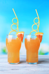 Grapefruit cocktail with cocktail straw on bright background