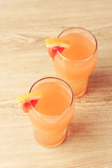 Grapefruit cocktail in glasses on wooden background