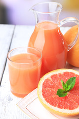 Half of grapefruit, glass jug with fresh juice and spoon
