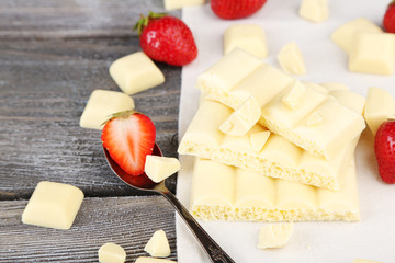 White broken chocolate bar on napkin on color wooden background © Africa Studio