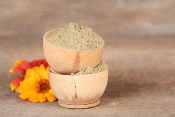 Dry henna powder in bowls on wooden table