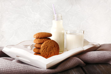 Milk and cookies on table on light grey background