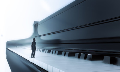 Obraz na płótnie Canvas Tiny man standing on a piano