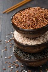 Assorted rice in bowl and chopsticks, top view