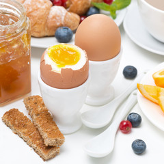 breakfast with eggs, toasts, croissants, fresh berries