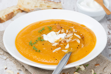 carrot soup with almonds, yogurt and watercress in a plate