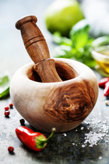 Obraz na płótnie Canvas Wooden Mortar and Pestle and chilli peppers, herbs and spices