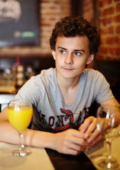 Teen having orange juice in a restaurant