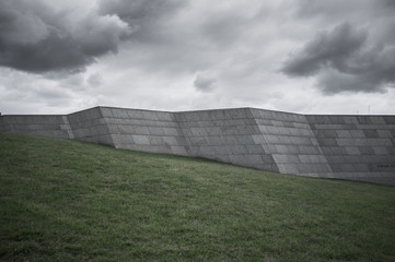 Fototapeta na wymiar High stone wall on a green hill