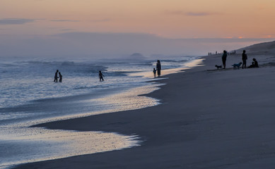 People relaxing on the beach at sunset