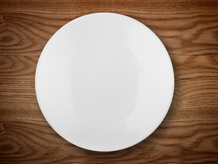 Empty white plate on wooden table