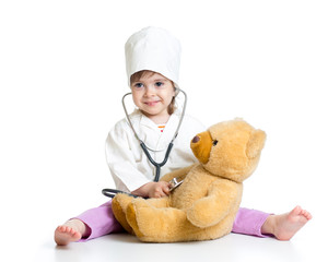 kid girl with clothes of doctor playing with toy