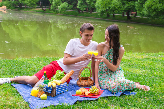 Young happy couple picnicking and relaxing outdoors