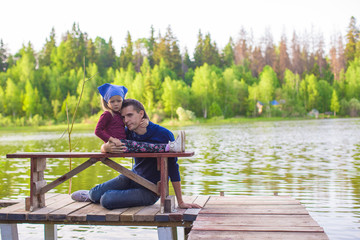 Fototapeta na wymiar Young father and little girl fishing outdoor