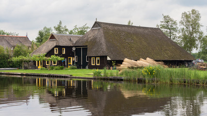 Fototapeta na wymiar Beautiful traditional house with a thatched roof in Blokzijl Hol