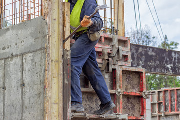 builder worker removing formwork elements with crowbar