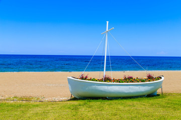 Flowers in a boat - pot on a beach in Polis, Cyprus