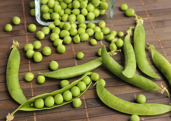 green peas pods on wooden table