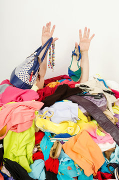 Man Hands Reaching Out From Big Pile Of Clothes And Accessories,