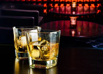 Fototapeten Whiskygläser mit Eis in einer Lounge-Bar © donfiore