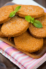Raw fish cutlets decorated with mint leaves, vertical shot