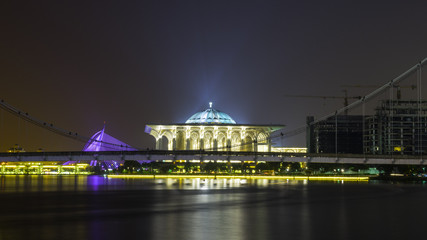 Bridge and modern mosque. Light reflection at night.