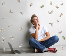 Young man surrounded by money