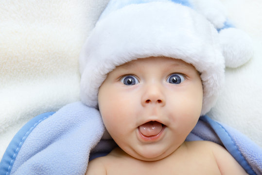 christmas cute baby boy, beautiful infant in Santa's hat and blu