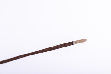 Incense stick on a wooden support on a white background