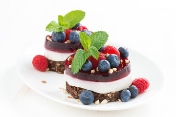 cakes with fruit jelly and fresh berries on a plate, horizontal