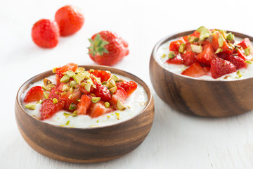 dessert of yogurt with fresh strawberries and pistachios in bowl