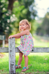 Portrait of a happy little girl in countryside at summer day