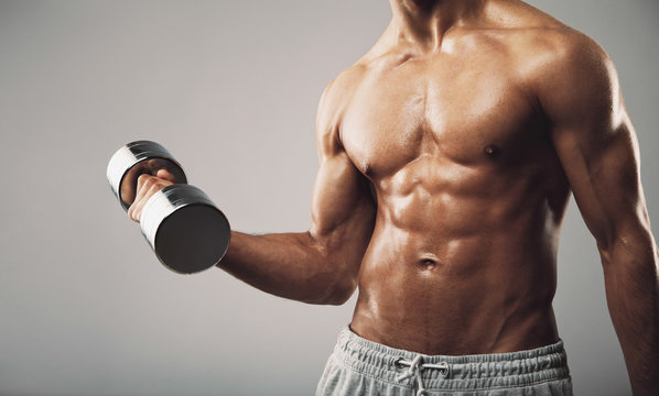 Fit Young Man Exercising With Dumbbells