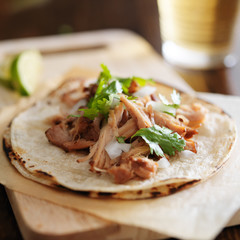 authentic mexican tacos with carnitas, cilantro and onion