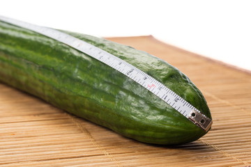 Closeup with a big cucumber and a centimeter.