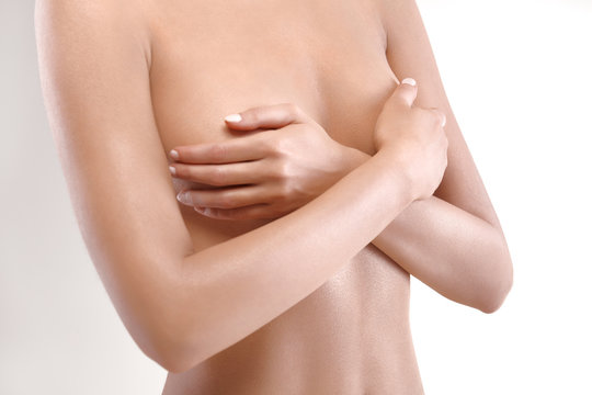 woman checking breast for signs of cancer