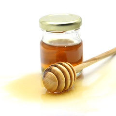 Honey and dipper on white background