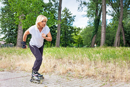 Elderly woman exercises in the park