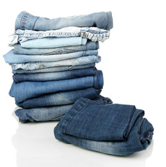 Lot of different blue jeans isolated on white