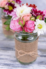 Beautiful bouquet of bright flowers in jars
