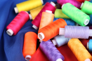 Multicolor sewing threads on color fabric background