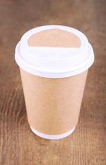 Paper cup of coffee on wooden table