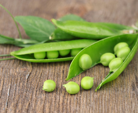 Fresh green peas on wooden table
